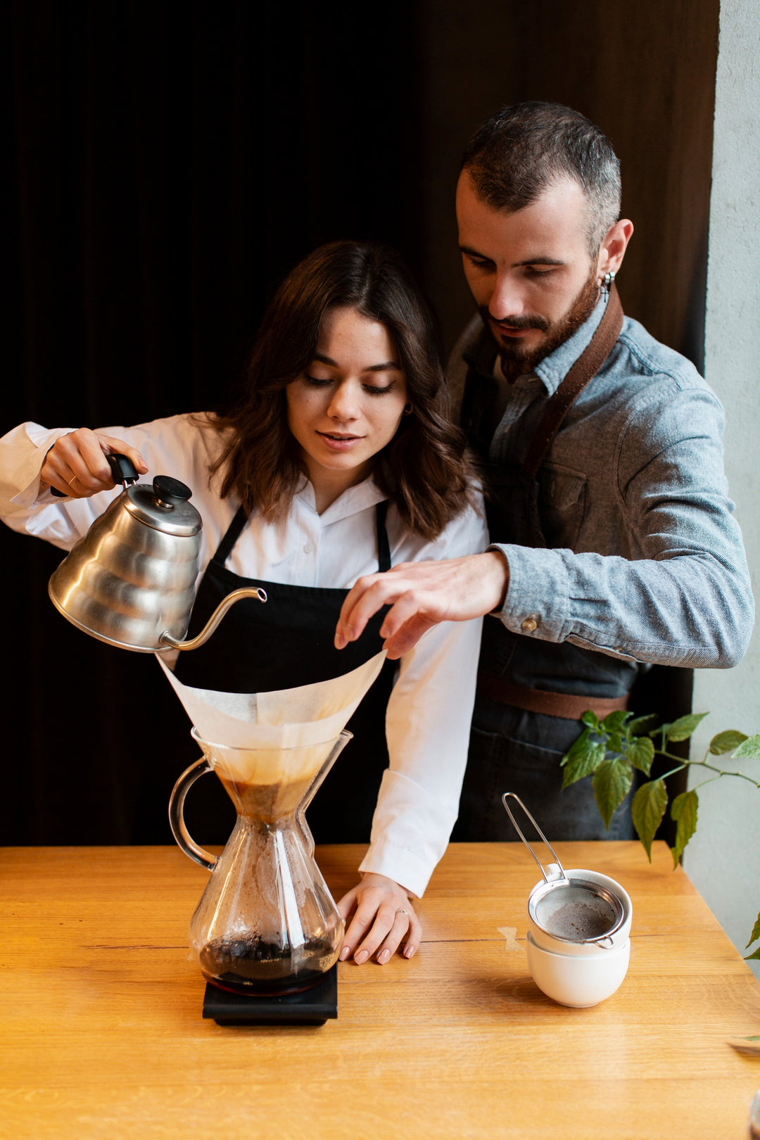 Man teaching a woman to filter coffee
