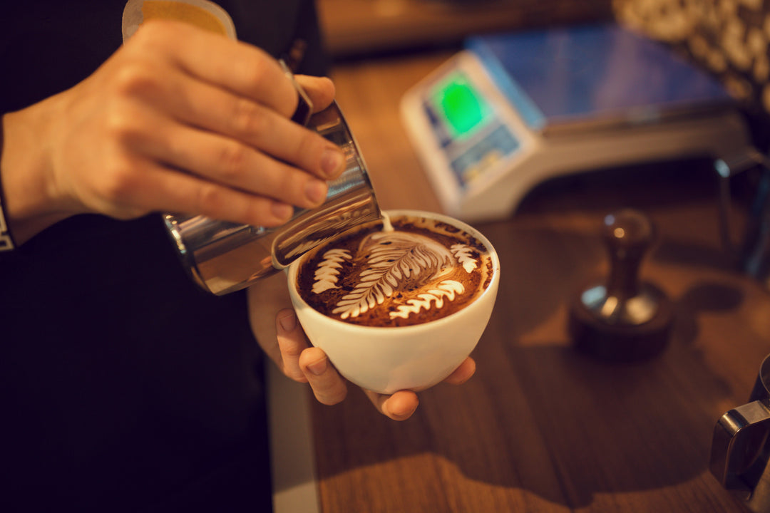 woman pouring cream into a coffee mug